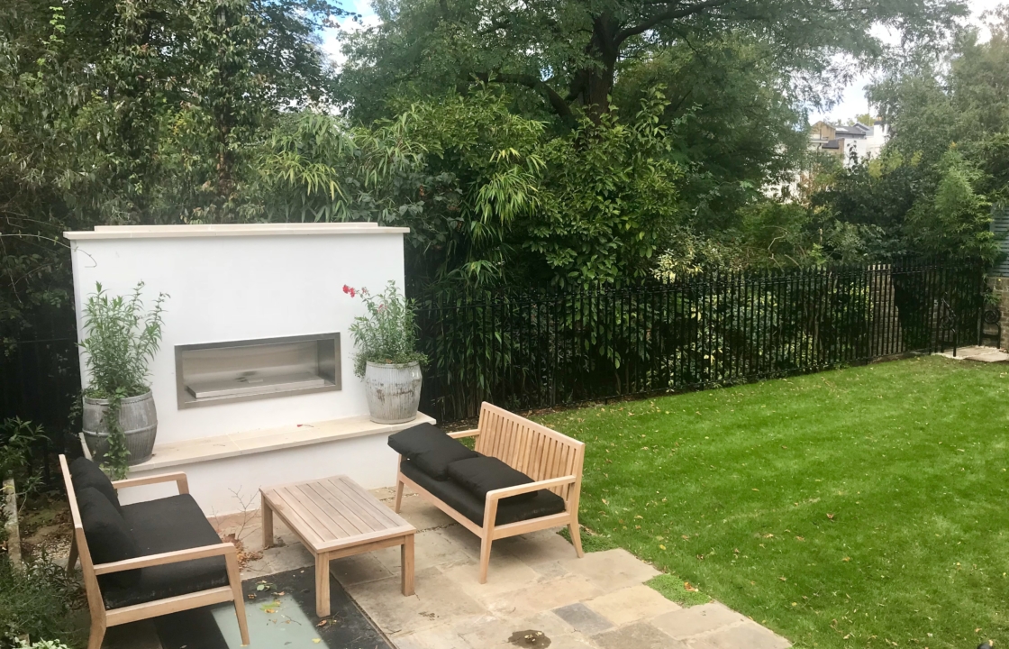 Bespoke external garden fireplace construction next to garden turf on the patio