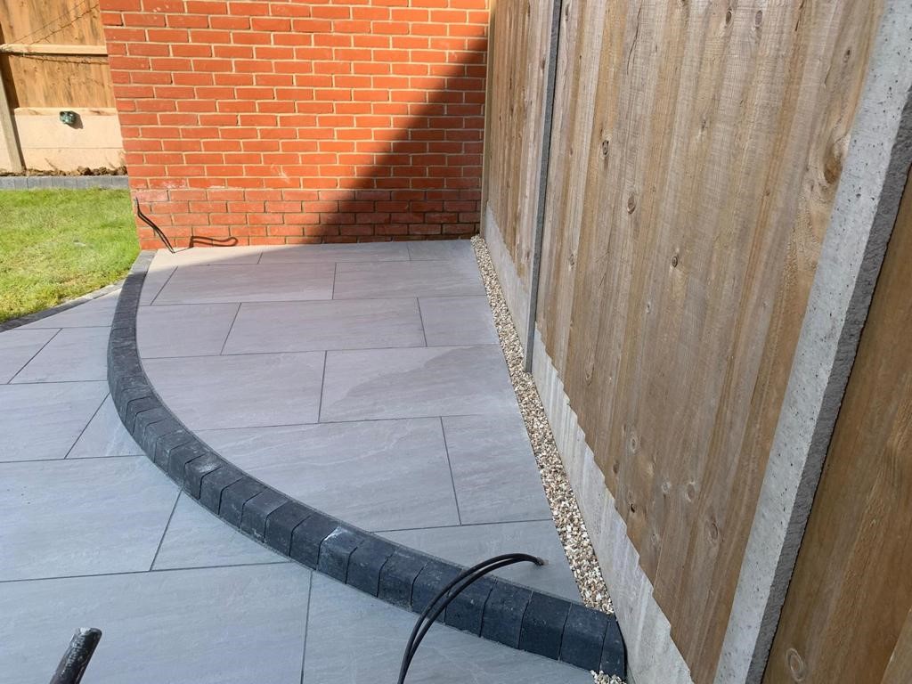 Kandla Grey porcelain slabs installed with Charcoal grey Key kerb edgings as part of a hard landscaping project in Essex with Greenstone Landscapes